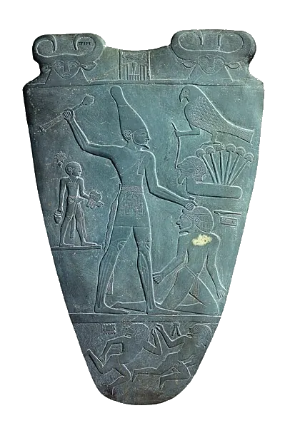 La Paleta de Narmer: un rey con corona blanca alza una maza ante un enemigo; arriba a la derecha, un halcón sobre papiros